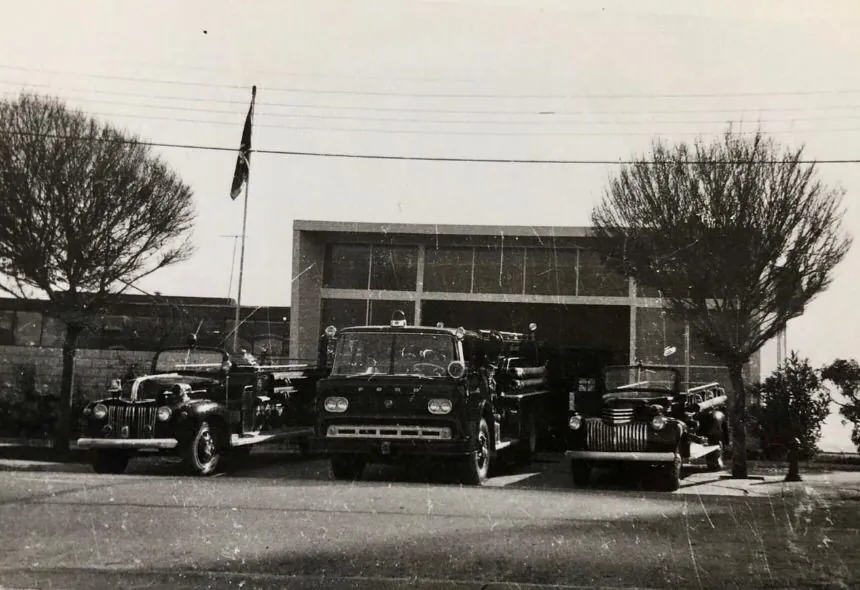 Fotografía en blanco y negro del cuartel de avenida San Martín, con tres carros al frente: la 4-A a la izquierda, la Ford 4000 al centro y, a la derecha, un Chevrolet más pequeño.